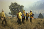 Fire line crew gathered on smoky hillside by Douglas Beck