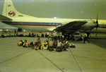 Smokejumpers seated on a tarmac near an airplane carrying fire retardant at Redding, California by Douglas Beck