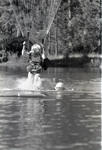 Smokejumper landing in water with parachute by Douglas Beck
