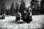Ron McMinnimy, Delos Dutton and Mick Swift sitting in a field by Douglas Beck