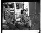 Two men sitting in front of a store front in town flooded by Grand Coulee Dam reservoir by Hubert Blonk