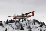 03. United States Forest Service Sherpa aircraft in flight over a snowy landscape by Ted Corporandy