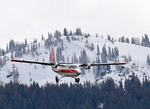 04. Twin Otter transport aircraft in flight over a snowy landscape by Ted Corporandy