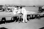Frank Derry and jump team member packing a parachute at Mines Field in Los Angeles, California by unknown