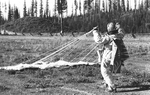 Smokejumper gathers parachute after landing by unknown