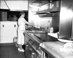 Woman at a grill in a Eastern Washington College of Education dining facility by Eastern Washington College of Education