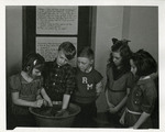 Experiment in which a student puts his hands in a bowl of water by Eastern Washington College of Education